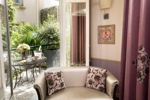 a living room with a chair in front of a window at Hotel Monceau Wagram in Paris