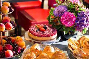 a table topped with pies and pastries and a cake at Hotel Monceau Wagram in Paris