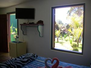 Televízia a/alebo spoločenská miestnosť v ubytovaní Chales das Andorinhas