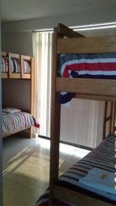 1 dormitorio con 2 literas y ventana en Chicama Surf Camp, en Puerto Chicama