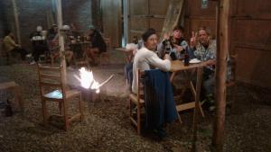 a group of people sitting at a table with a fire at Chicama Surf Camp in Puerto Chicama