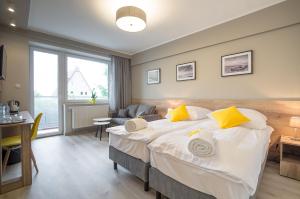 a bedroom with a large bed with yellow pillows at Villa Baltica II in Rewa