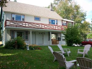 une maison avec 2 chaises longues dans la cour dans l'établissement Mohican Motel, à Cooperstown