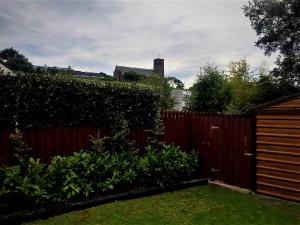 een hek in een tuin naast een heg bij Greenway View B&B in Newport