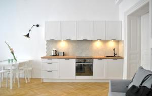 クラクフにあるFlorianska Apartmentの白いキッチン(白いキャビネット、テーブル付)