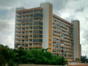 un edificio alto con árboles delante de él en Ikeda Hoteis, en Brasilia