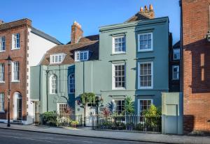 a green house on a street with brick buildings at Ye Spotted Dogge in Portsmouth