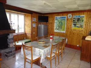 a kitchen with a table with chairs and a refrigerator at Gîtes La Coquille in Ternuay-Melay-et-Saint-Hilaire