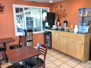 ein Restaurant mit einem Tisch, Stühlen und einer Theke in der Unterkunft Bestway Inn in Grants Pass