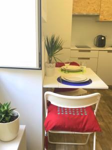 リスボンにあるIntendente Loftの白いテーブル(赤い枕の椅子付)