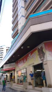 una tienda frente a un edificio con gente de pie fuera en Apartamento Meia Praia, en Itapema