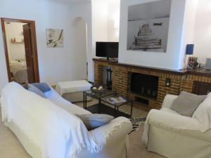 a living room with white furniture and a fireplace at Casa Coromines in Alcudia