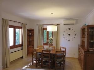 a dining room with a table and a clock on the wall at Casa Coromines in Alcudia