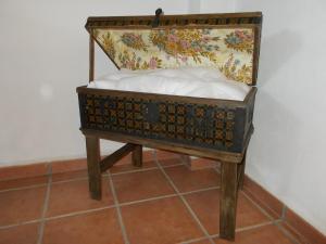 een klein bed met een kist op een vloer bij La Tierra Verde STUDIO in Alcuéscar