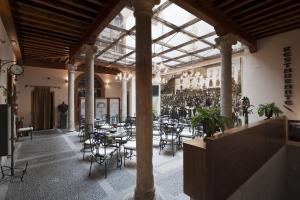 a restaurant with tables and chairs in a building at Posada Real Los Cinco Linajes in Arévalo