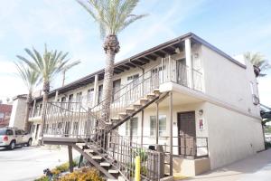 a building with palm trees in front of it at Tuscan Garden Inn in Los Angeles