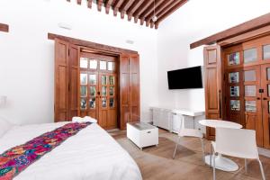 a bedroom with a bed and a desk and a tv at Domingo Santo Hotel Boutique in Mexico City