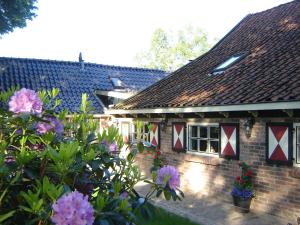 a brick house with flowers in front of it at Bed en Breakfast De Boksloot in Ravenswoud