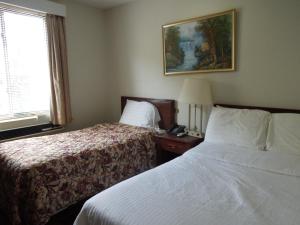 a hotel room with two beds and a window at Windsor Hotel in New York