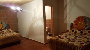 a room with two beds and a persons shadow on the wall at Hotel Jardin Rincon de las Estrellas in Velasco +16 photos