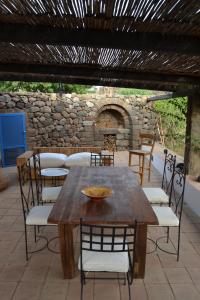 a wooden table and chairs on a patio at BIOdammuso in Pantelleria