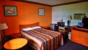 Habitación de hotel con cama y escritorio en Nassau Holiday Motel, en Yulee