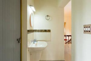 Baño blanco con lavabo y espejo en Stay at DBRA 61 Don Bosco Cross Road Vaduthala Ernakulam, en Kochi