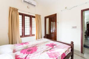a bedroom with a bed with a floral comforter at Stay at DBRA 61 Don Bosco Cross Road Vaduthala Ernakulam in Cochin