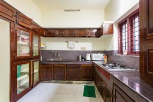 a kitchen with wooden cabinets and a counter top at Stay at DBRA 61 Don Bosco Cross Road Vaduthala Ernakulam in Cochin
