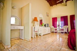 uma sala de estar com uma cama, uma mesa e cadeiras em Silver Seas Hotel em Ocho Rios