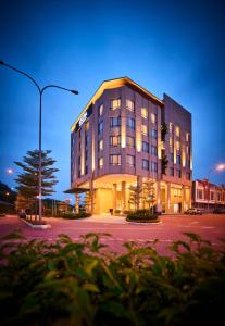 a large building with lights on in a parking lot at d'Sora Boutique Business Hotel in Kampong Baharu Jimah