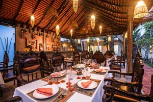 uma sala de jantar com mesas e cadeiras num restaurante em Mane Village Suites em Siem Reap