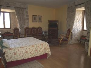a room with a bed, table, chairs and a window at Residencia Real del Castillo de Curiel in Curiel de Duero