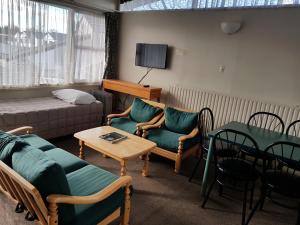 a living room with a couch and chairs and a table at Manhattan Motel in Rotorua