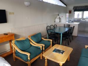 a living room with a table and chairs and a dining room at Manhattan Motel in Rotorua