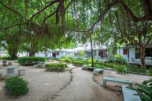 a park with benches and trees and a building at Da Kanda Villa Beach Resort in Thong Sala