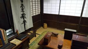 a room with a desk and a table in a room at Minshuku Suhara in Okuwa