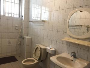 a bathroom with a toilet and a sink and a mirror at Yuan Gong Yuan in Longtian