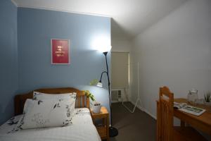 プエルト・プリンセサにあるAmor's Placeのベッドルーム(ベッド1台、デスク、ランプ付)