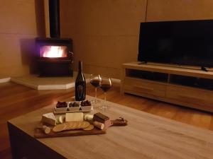 a living room with a table with a bottle of wine and wine glasses at Jarrah Grove Forest Retreat in Rosa Glen