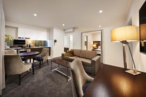 a living room with a couch and a table at Attika Hotel in Perth