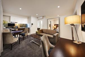 a living room filled with furniture and a tv at Attika Hotel in Perth