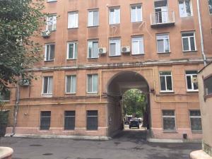 un grande edificio in mattoni con un arco davanti di Apartment Dekabrystiv a Mykolaïv