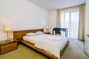a bedroom with a bed and a large window at City Gardens Hotel & Wellness in Budapest