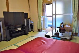 ein Wohnzimmer mit einem Flachbild-TV und einem Sofa in der Unterkunft Guest House WASSO in Kyoto