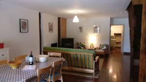 a dining room with a table and a couch at Cottages de Garrigue in Fonroque
