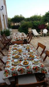 a table with plates of food on a patio at B&B Le Macine 1868 in Paceco