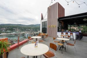 een restaurant met tafels en stoelen op een balkon bij Front One Hotel Jayapura in Jayapura