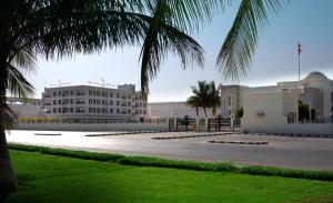 a building with a palm tree in front of it at Gateway Salalah Apartments in Salalah
