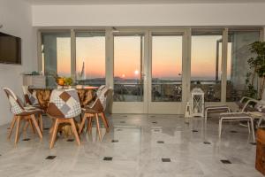 sala de estar con mesa y sillas con vistas en Island View Santorini, en Pirgos